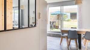 Ein modernes Interieur mit Essbereich, großen Fenstern und Blick ins Freie.
