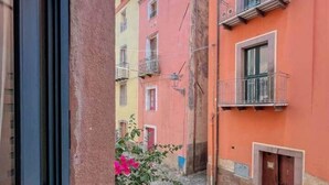Eine enge Straße mit Kopfsteinpflaster, bunten Häusern und einem Fensterrahmen.