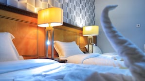 A hotel room with two beds, each with a lamp and a pillow. - MANART ALMISK HOTEL (Makkah)
