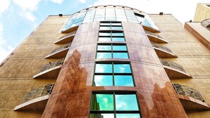 A tall building with a curved facade, large windows, and balconies. - MANART ALMISK HOTEL (Makkah)
