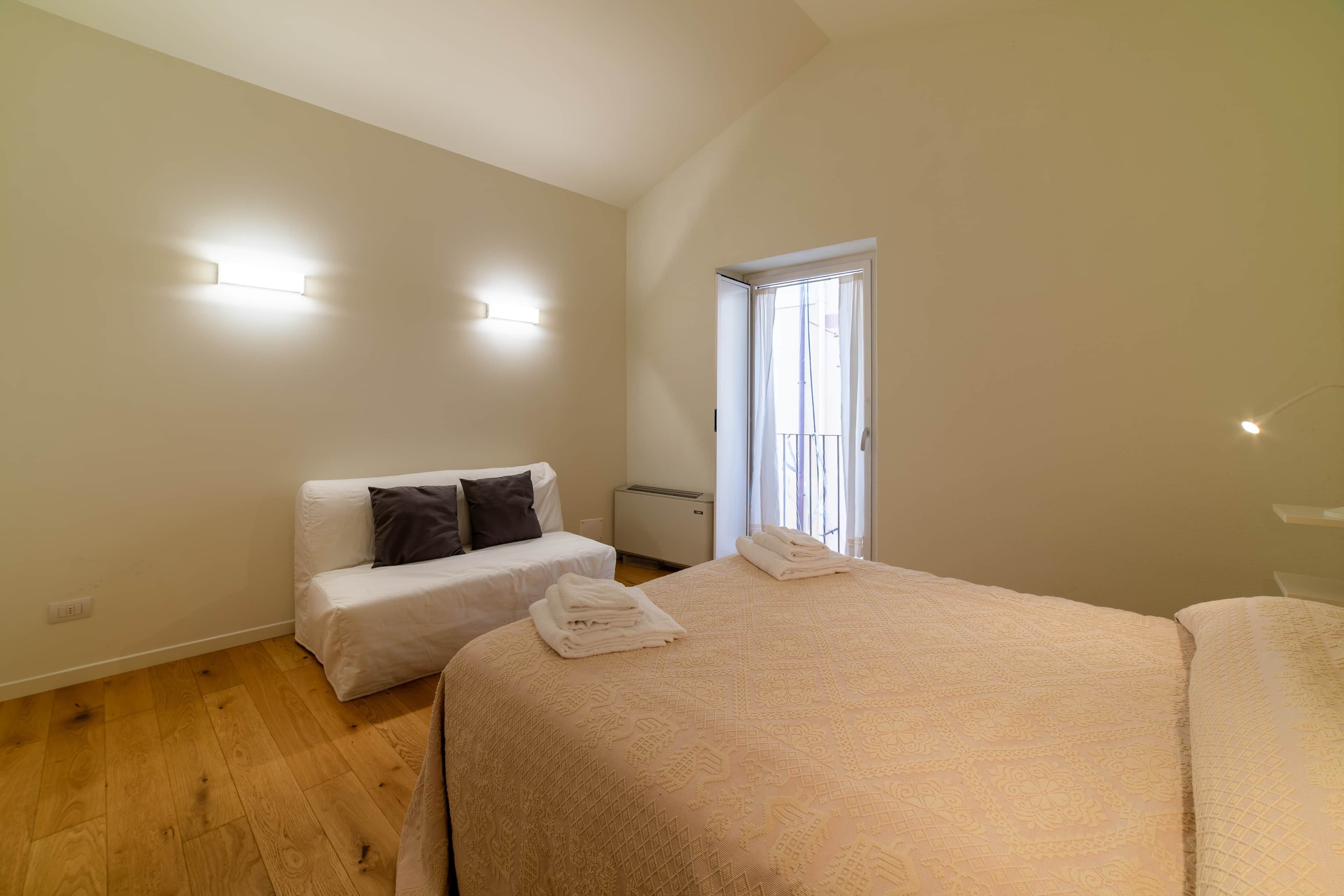 Un dormitorio con dos camas, una ventana y un radiador.
