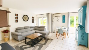 A modern living room with a sofa, coffee table, and dining area with chairs and a table. - De Standing Avignon Apartment with Wi-Fi and Air Conditioning (Avignon)