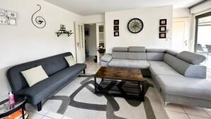 A living room with a grey sofa, a dark grey sofa, a wooden coffee table, and a patterned rug. - De Standing Avignon Apartment with Wi-Fi and Air Conditioning (Avignon)