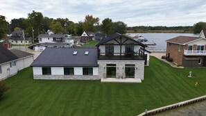 Een modern herenhuis met twee verdiepingen, een plat dak, een gevel van natuursteen en een ruim terras.