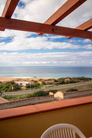 A balcony with a view of the beach and ocean. - Sardinian Gallery Porto (Tresnuraghes)