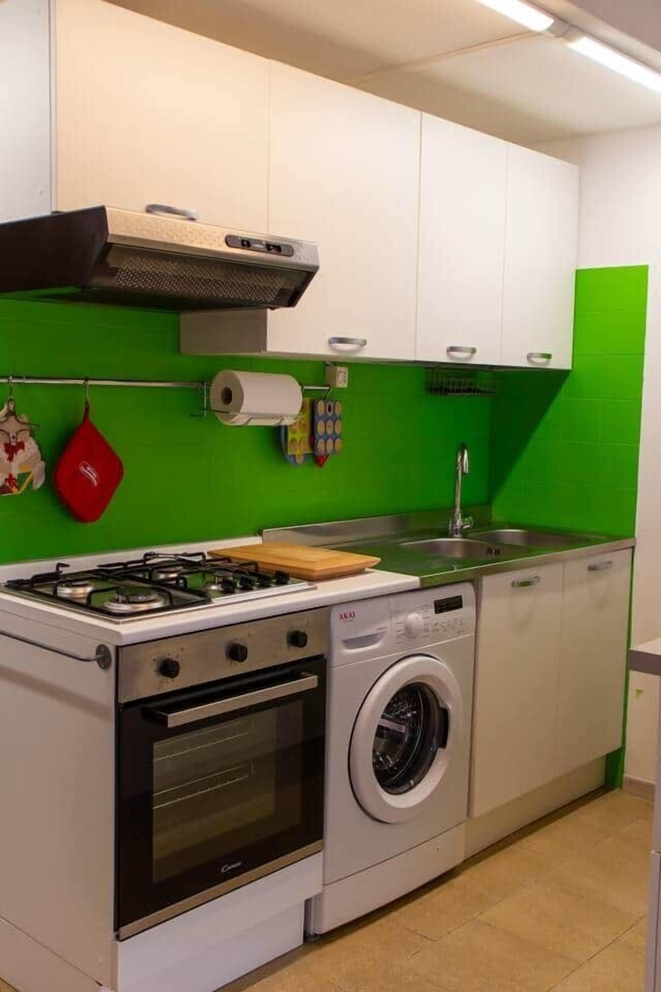 A compact kitchen with a gas stove, oven, and washing machine.