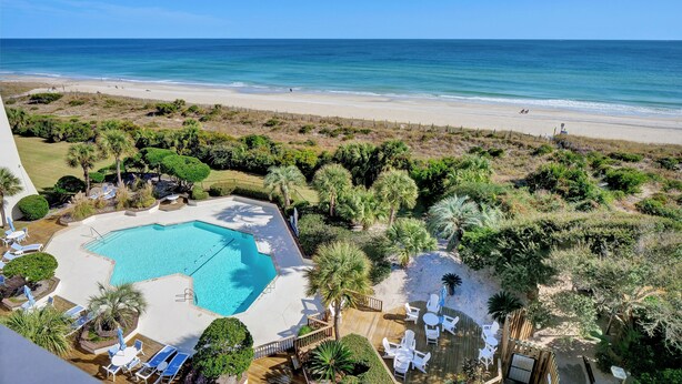Ein Resort mit Swimmingpool, Strand und Palmen.