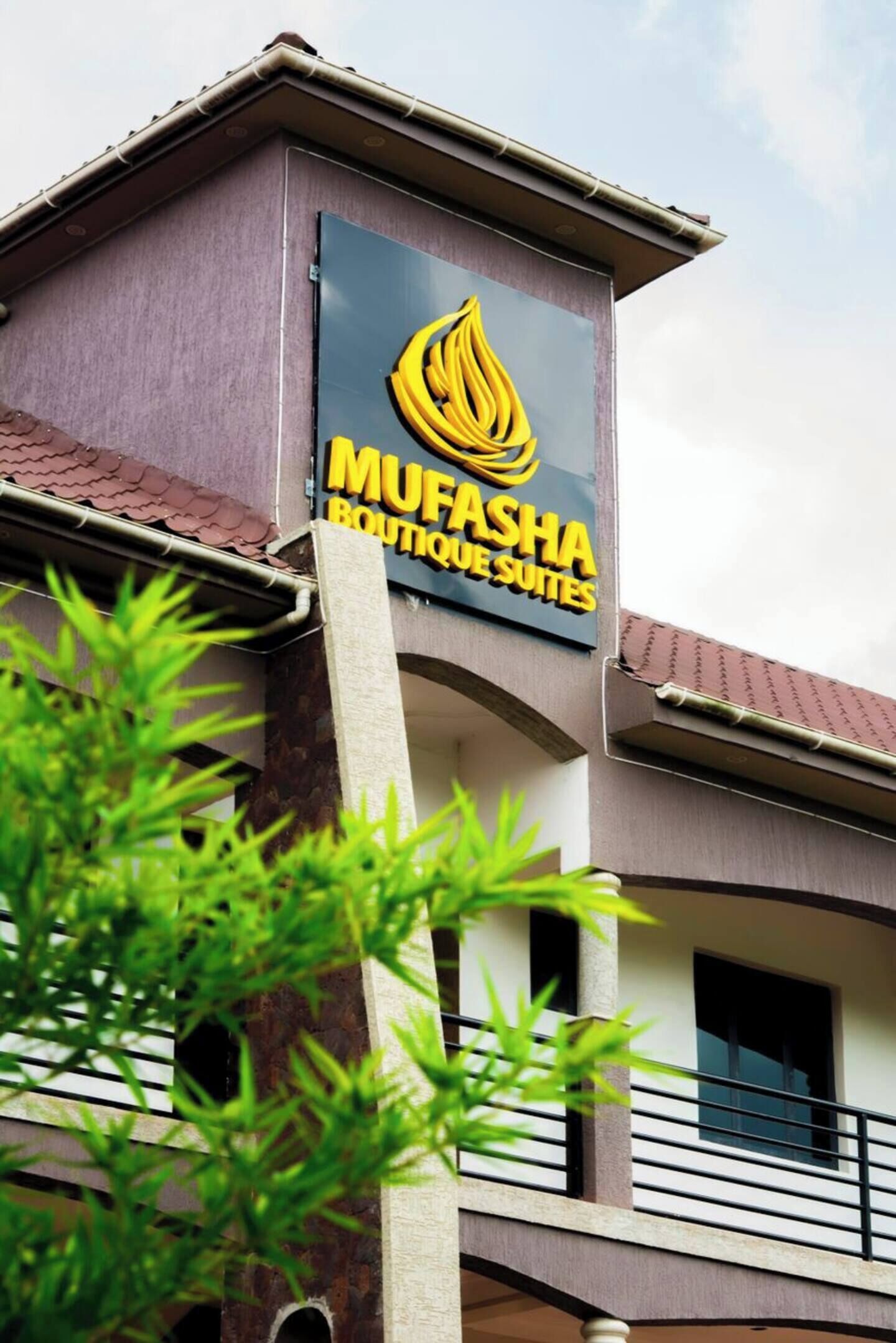 A building with a sign for "MUFASA Boutique Suites" featuring a stylized flame logo.