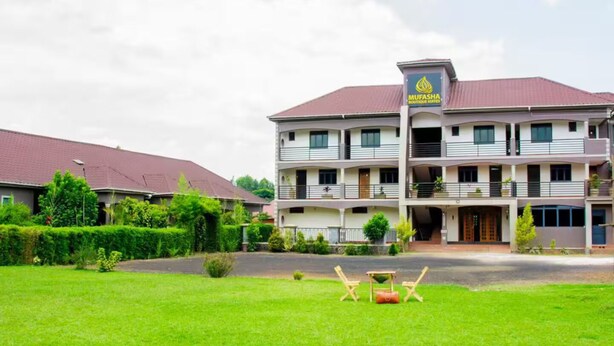 Ein mehrstöckiges Hotel mit rotem Dach und einem Schild mit der Aufschrift 'MUFASA'.