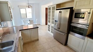A modern kitchen with stainless steel appliances, a built-in oven, and a microwave.