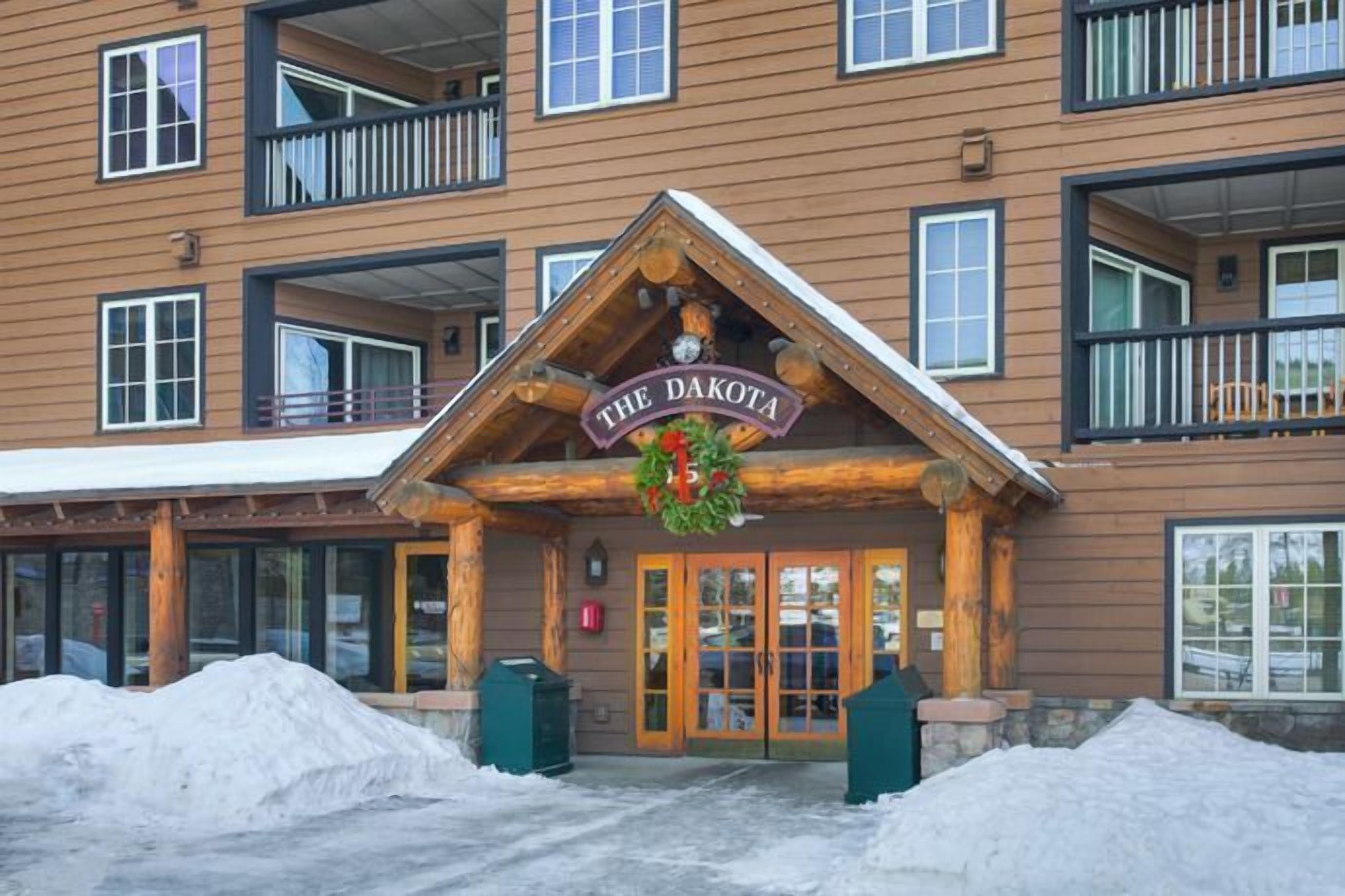 Eine Lodge mit einem auffälligen Schild, auf dem "THE DAKOTA" steht, und einer Holzwand.