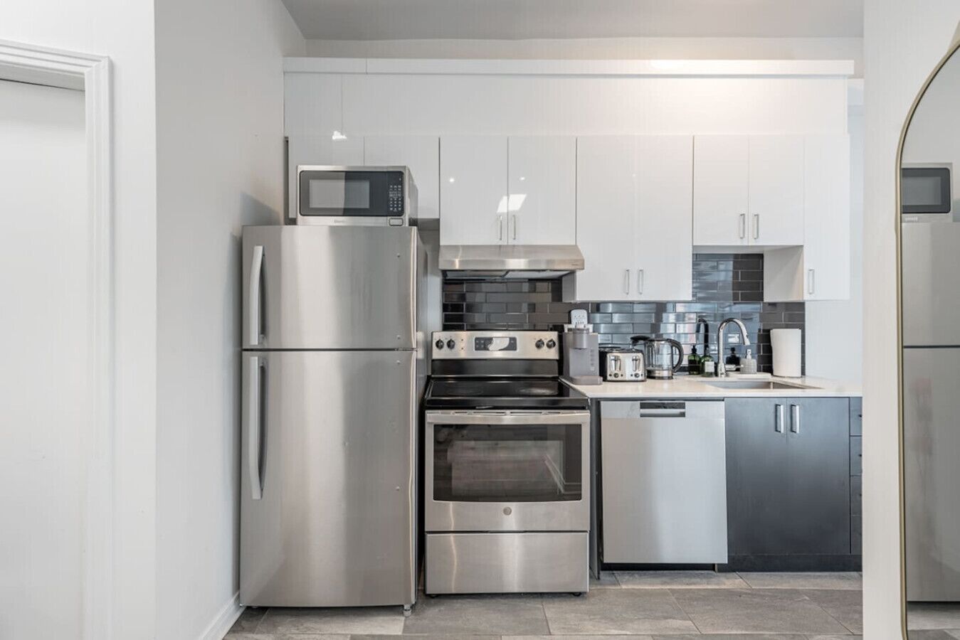 A modern kitchen with stainless steel appliances, including a refrigerator, oven, and microwave.