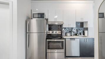 A modern kitchen with stainless steel appliances, including a refrigerator, oven, and microwave.