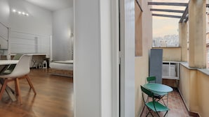 Eine moderne Wohnung mit Essbereich, einem Balkon mit Stadtblick und einem großen Fenster.
