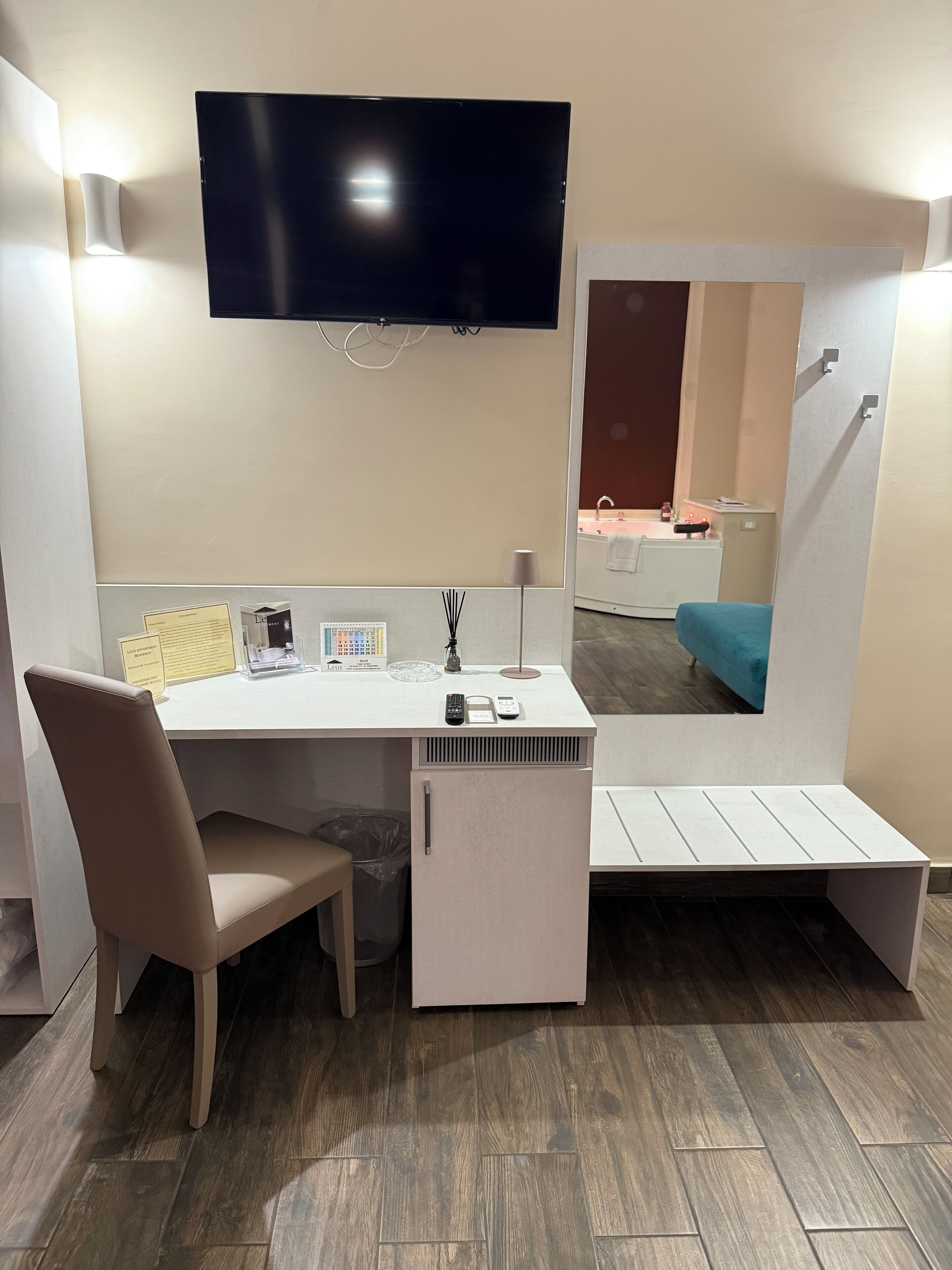 A modern room with a desk, chair, and a TV mounted on the wall.