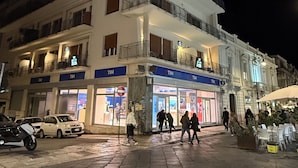 A multi-story building with a ground-level shop and upper-floor balconies. - B&B Leus Appartment (Reggio Calabria)