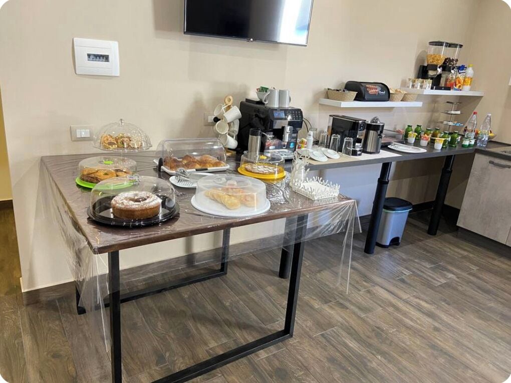 Disposição de buffet com diversos alimentos e máquinas de café.