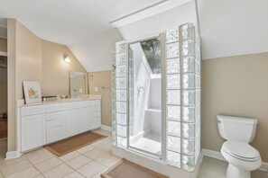 A bathroom with a glass shower enclosure, a white toilet, and a vanity with drawers and a mirror. - 10 Gunnery Lane ~Heart of Sea Pines | Bike to Beach (Hilton Head Island)