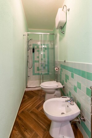 Un baño con ducha, inodoro y lavamanos.
