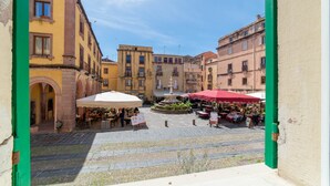 Un patio con mobiliario exterior, una fuente y edificios con balcones.