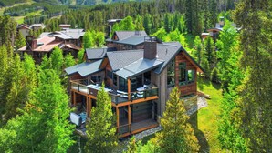 A modern log cabin with multiple levels, large windows, and a deck area. - Walk-to-Ski Retreat | Serac Lodge (Breckenridge)