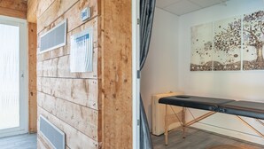 A wooden wall with vents, a massage table, and a wall art piece. - “Nature Room” Guesthouse with Shared Terrace, Wi-Fi, and Air Conditioning (Saint-Savin)