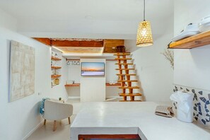 Eine moderne Küche mit einer zentralen Kochinsel, Holzregalen und einer hängenden Leuchte.