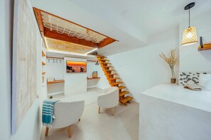 Ein modernes Interieur mit einer Holztreppe, weißen Wänden und einer Sitzecke mit Sonnenuntergangsblick.