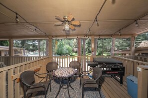 An outdoor patio with a round table, four chairs, a ceiling fan, and a grill. - Innsbrook Vacation Condo 30 (Ruidoso)
