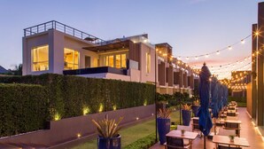 Ein modernes Hotel mit Dachterrasse, Sitzgelegenheiten im Freien und Lichterketten.