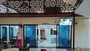 A spacious lobby with a high ceiling, a decorative black railing, and a view into the restaurant area. - The Heritage Resort (Wajir)
