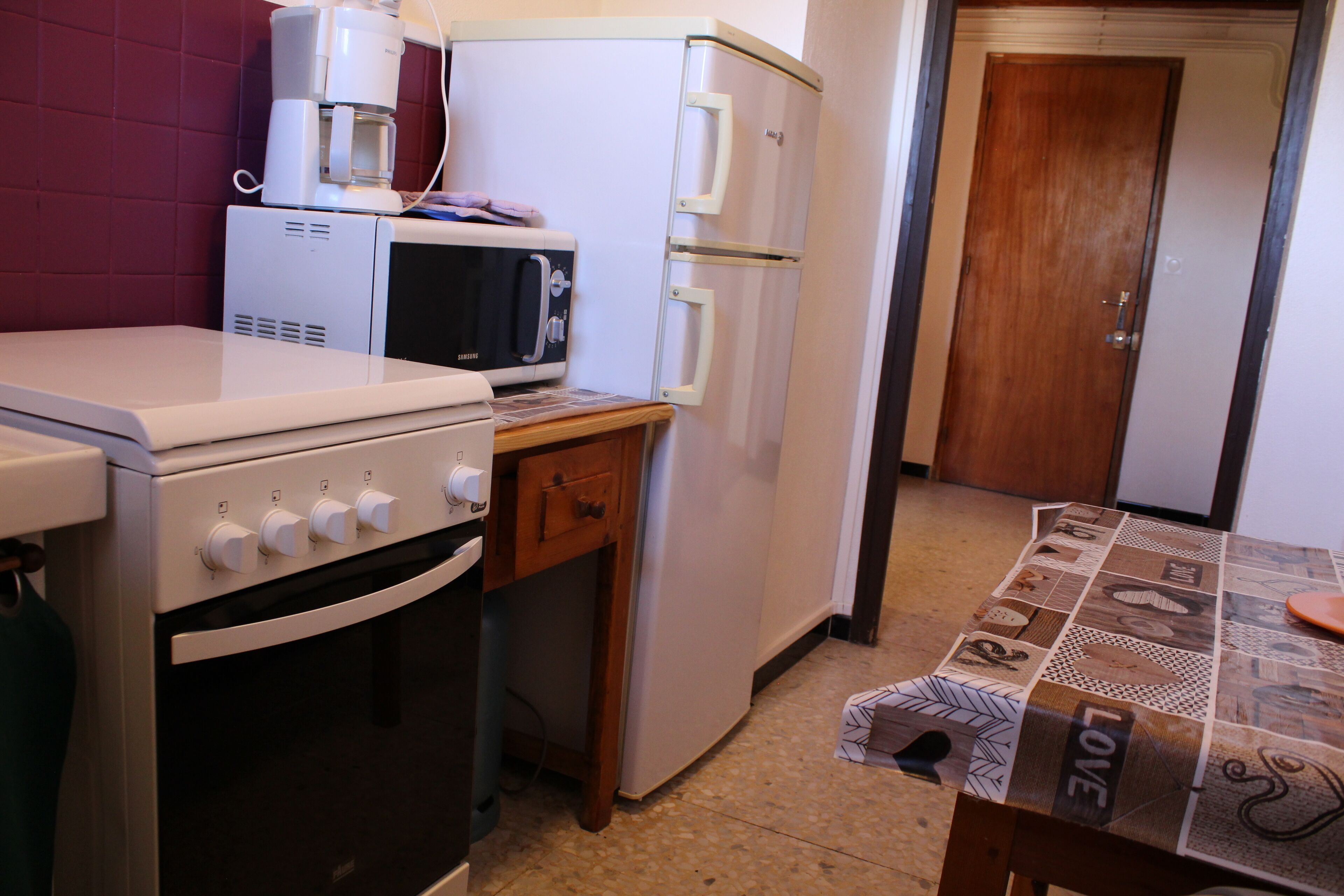 A compact kitchen with a microwave, oven, and refrigerator.