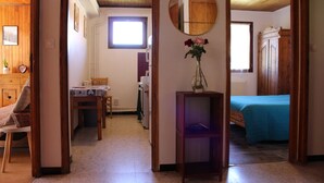 Una stanza con un letto, un tavolino con sedie, uno specchio e una finestra.