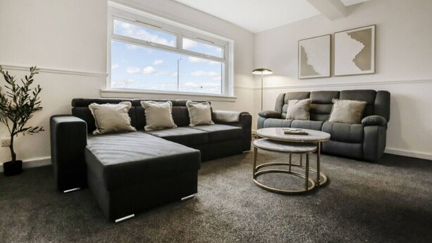 A living room with a sectional sofa, a round coffee table, and a floor lamp. - Free Parking | Central | Sleeps 6 | 3 Bedrooms (North Lanarkshire)