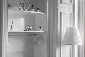 A white interior with a white door, a white lamp, and shelves with plants and decorative items. - Free Parking | City Centre | Sleeps 9 | 3 Bedrooms (Edinburgh)