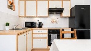 A compact kitchen with a microwave, coffee maker, and a black refrigerator. - Stunning 1-Bedroom Flat in Edinburgh | Sleeps 3 (Edinburgh)