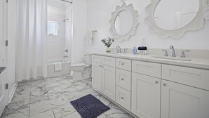 Un bagno moderno con vasca, servizi igienici e mobile lavabo.