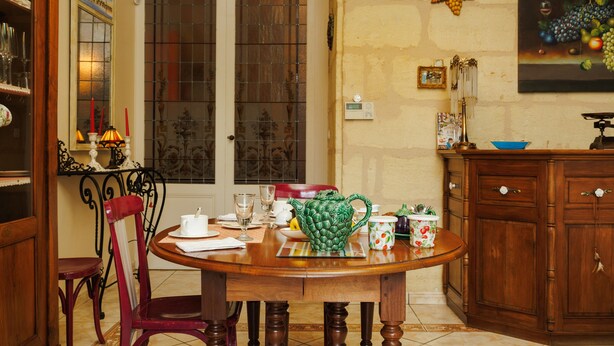 Un coin repas comprenant une table en bois, des chaises, un buffet et une fenêtre donnant sur un paysage agréable.