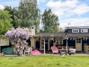 A house with a covered porch, a chimney, and a tree with purple flowers. - 4 Star Holiday Home in Gilleleje (Gilleleje)