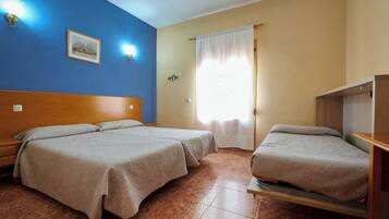 Habitación de hotel con dos camas, cabecero de madera, mesita de noche, lámpara de pared y ventana con cortinas.
