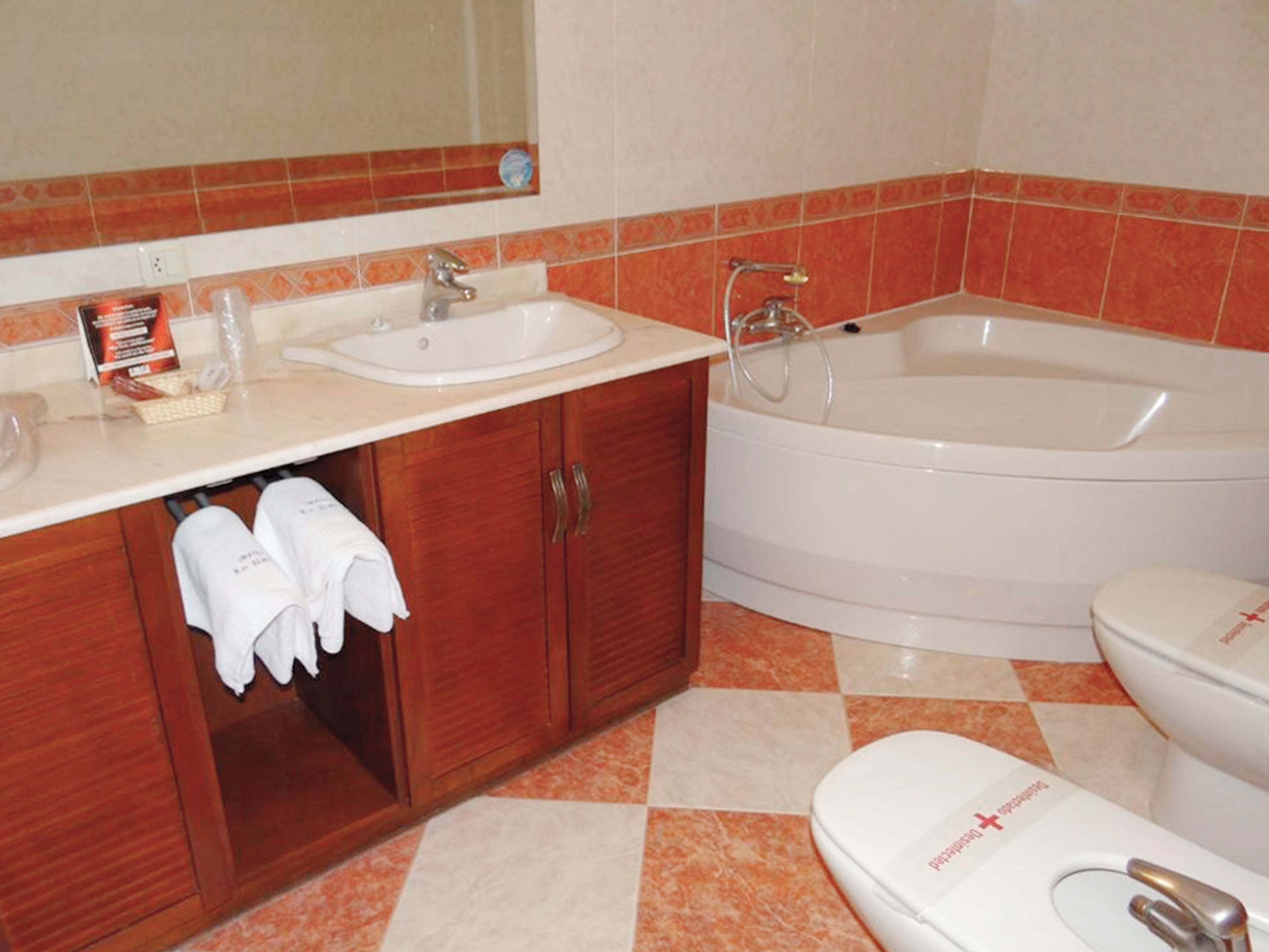 Un baño con lavamanos, espejo y bañera.