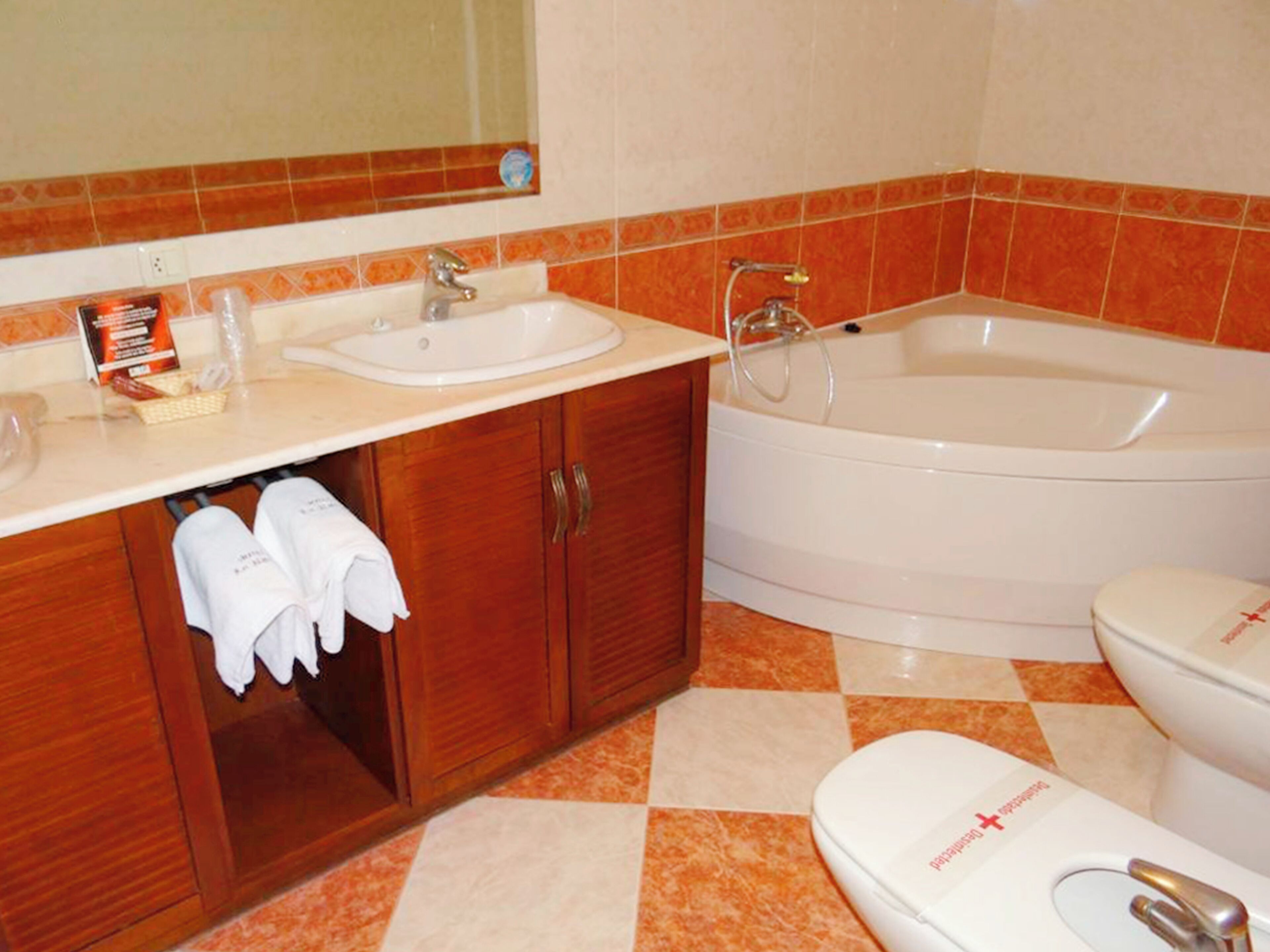 A bathroom with a sink, mirror, cabinet, and bathtub.