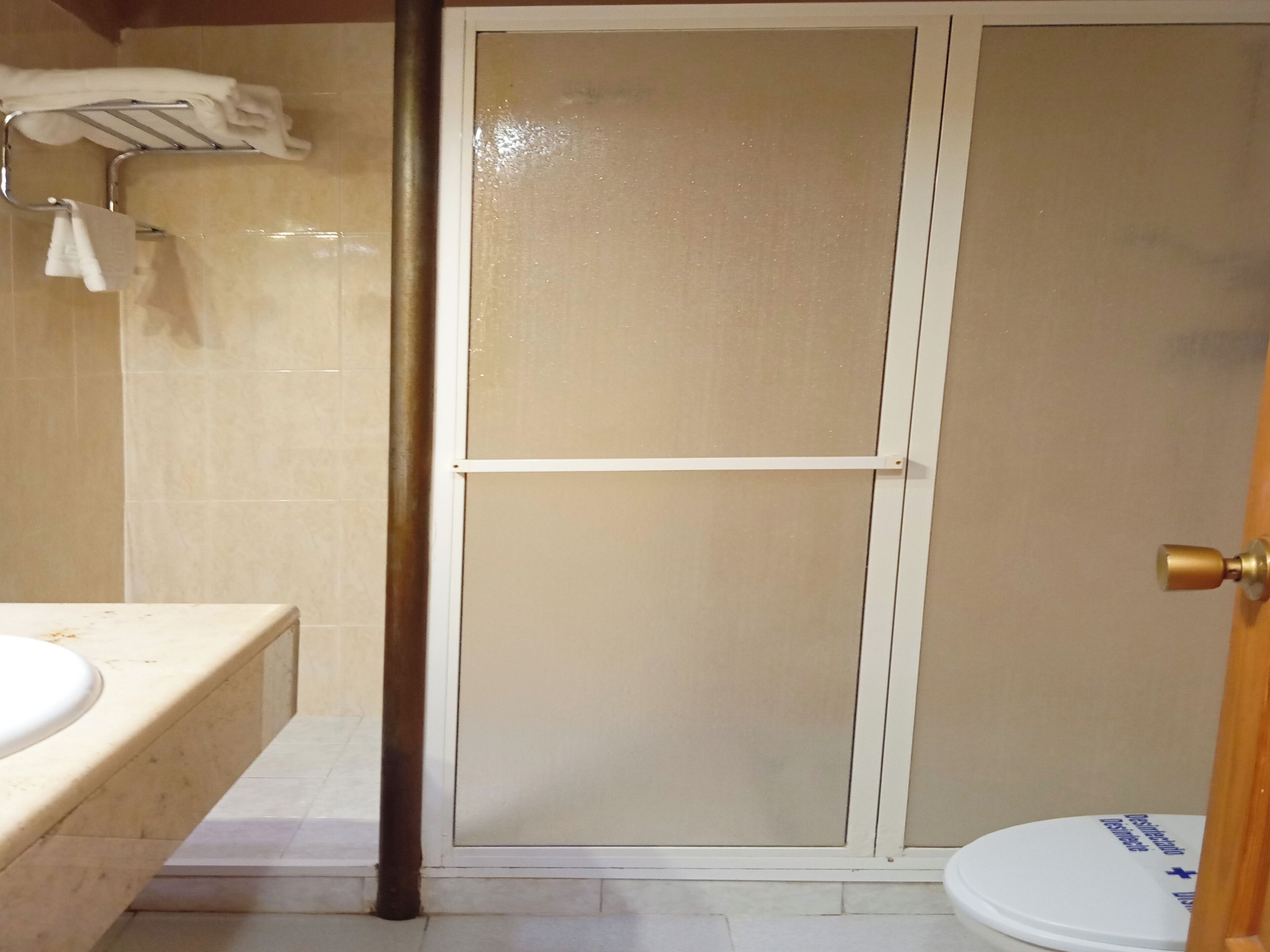 Un baño con cabina de ducha, inodoro y lavamanos.