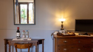 A hotel room with a wooden desk, a chair, a dresser, a television, a lamp, and a mirror. - Camera Lanciotta - Monticchiello (Monticchiello)