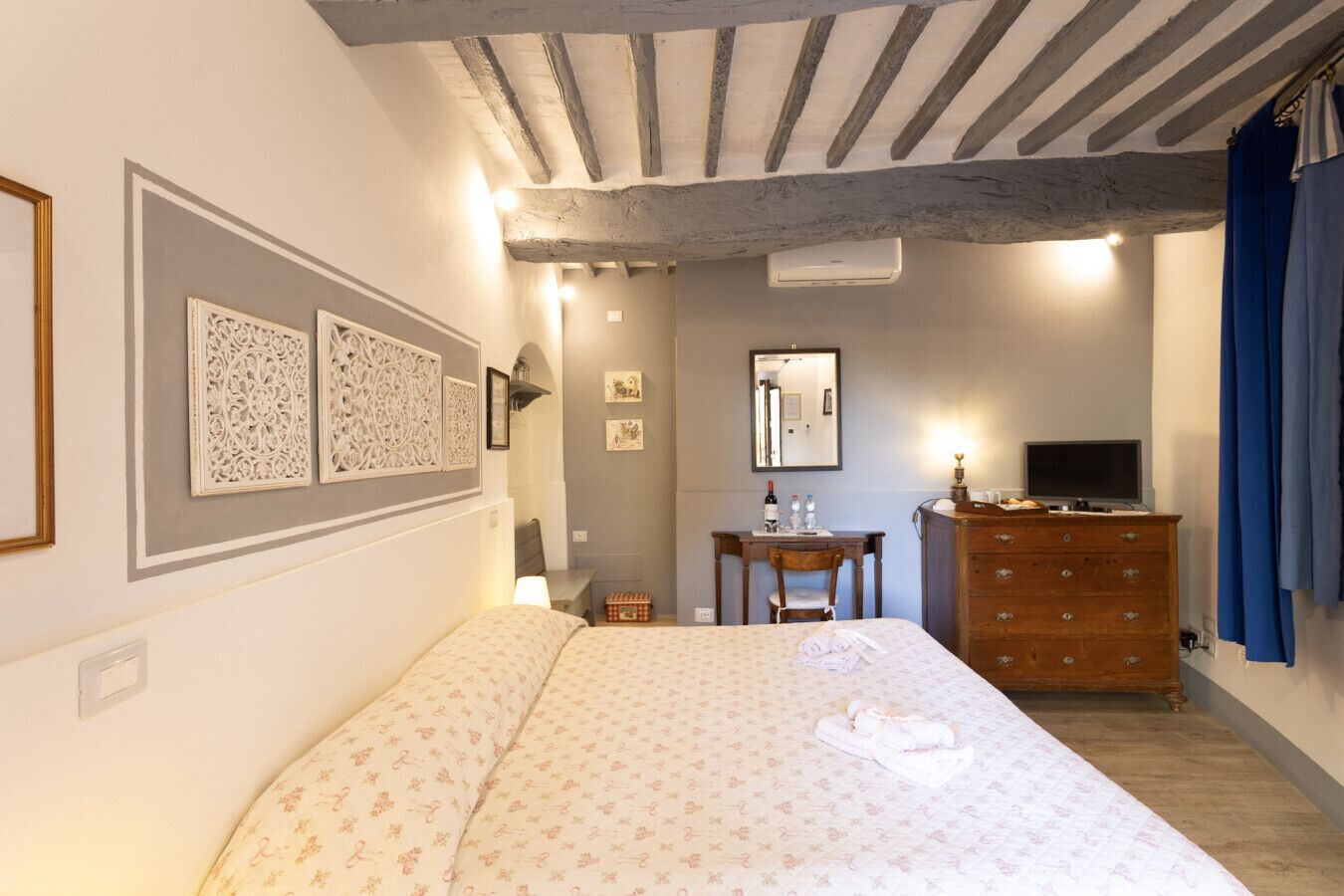 Une chambre à coucher comprenant un lit, une commode, un bureau et un miroir.