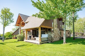 A two-story lodge with a stone exterior and a covered porch area. - New! Ski In/Ski Out Home w/ Hot Tub & Fireplace (McHenry)