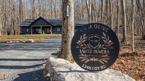 Een bordje voor Santo Olive, een lodge met een rustieke blokhut en een grindpad.