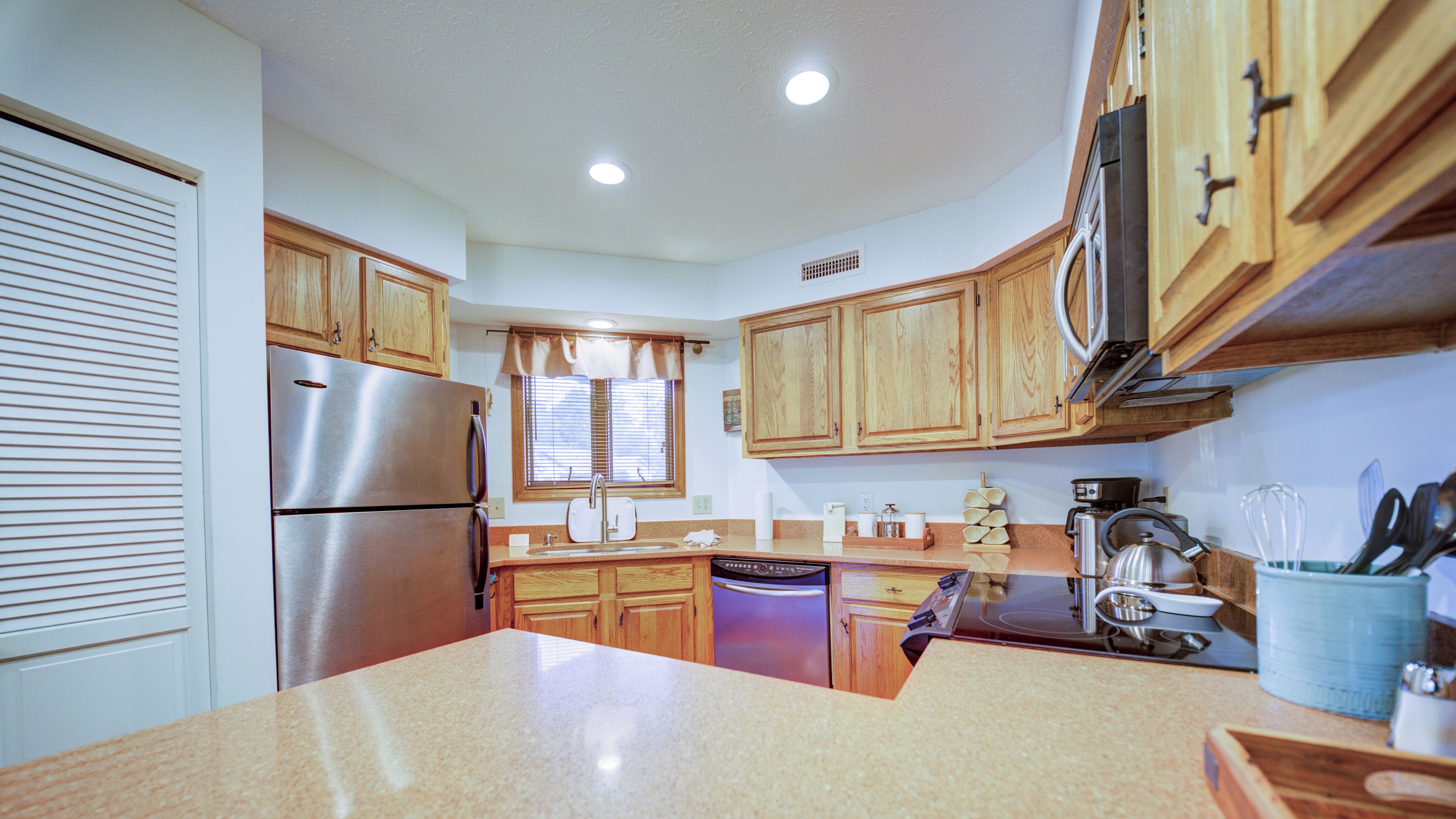 A kitchen with wooden cabinets, stainless steel appliances, and a granite countertop.