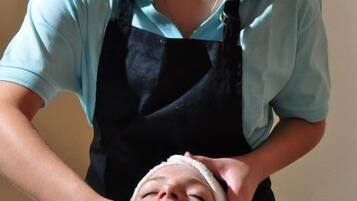Une personne allongée sur un lit en train de recevoir un soin du visage.