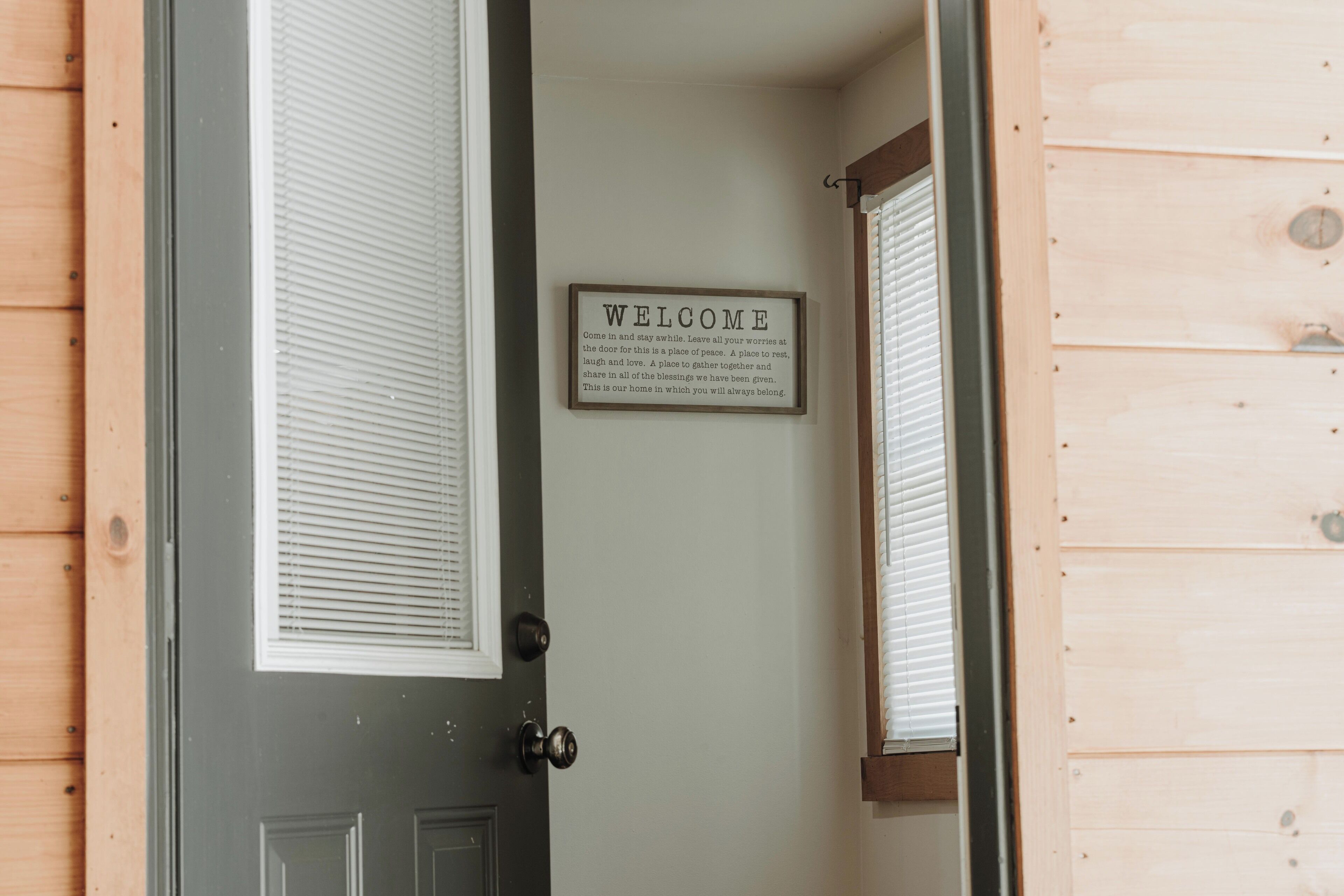 Une porte en bois avec une pancarte « BIENVENUE » au-dessus.